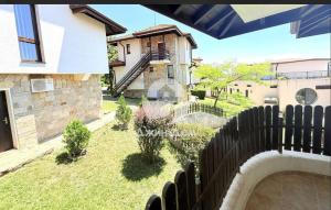 a backyard with a wooden fence and a house at Dimi's Bay View Villas in Kosharitsa