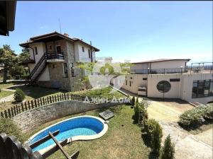 a villa with a swimming pool and a house at Dimi's Bay View Villas in Kosharitsa