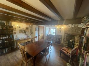 a dining room with a table and a fireplace at Honey Meadow Retreat in Ashreigney