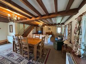 a dining room with a table and a living room at Honey Meadow Retreat in Ashreigney +23 photos