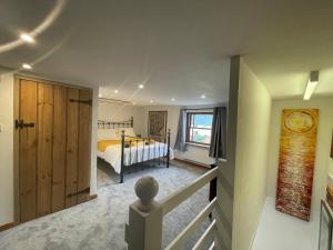 a bedroom with a bed and a wooden door at Honey Meadow Retreat in Ashreigney