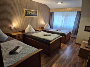a hotel room with two beds and a window at Gästehaus Hein in Emsbüren