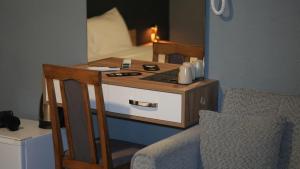 ein kleiner Schreibtisch mit einem Bett in einem Zimmer in der Unterkunft Hotel Ari in Prizren