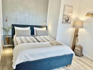 a blue and white bedroom with a large bed at Hof Steinhütten in Westerhever +18 photos