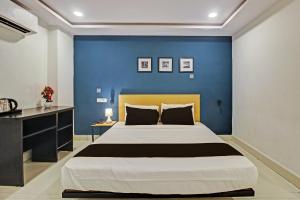 a bedroom with a large bed with a blue wall at Hotel O Qualia Miyapur in Hyderabad +24 photos