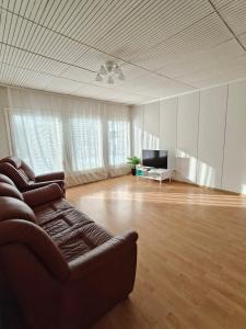 a living room with a couch and a television at Simple Cozy House in Raahe