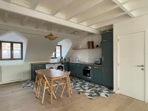a kitchen with green cabinets and a wooden table at Triplex de charme avec vue in Brussels