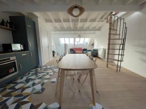 a kitchen with a table and a staircase in a room at Triplex de charme avec vue in Brussels