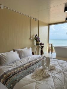 a bedroom with a large bed with a towel on it at Sand Bara in Ban Pak Ba Ra