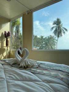 two swans making a heart on a bed with a window at Sand Bara in Ban Pak Ba Ra