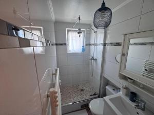 a white bathroom with a shower and a sink at Stephan house in Tremblay-En-France