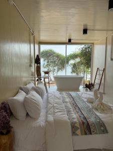 a bedroom with a large bed with a bath tub at Sand Bara in Ban Pak Ba Ra