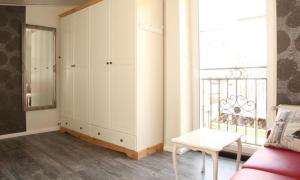 a living room with white cabinets and a window at Dat Witte Huuske in Emden