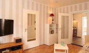 a living room with a flat screen tv on a striped wall at Dat Witte Huuske in Emden
