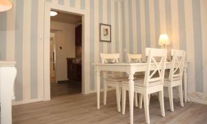 a dining room with a white table and chairs at Dat Witte Huuske in Emden +2 photos