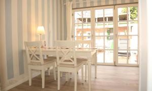 a white dining room with a table and chairs at Dat Witte Huuske in Emden