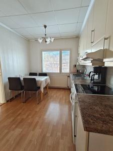 a kitchen with a table and some chairs in a room at Simple Cozy House in Raahe