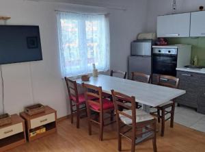 a kitchen with a table and chairs and a kitchen with a television at Stomorska Seaside Apartments in Stomorska