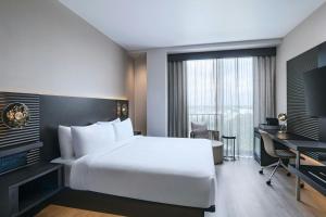a bedroom with a large white bed and a desk at AC Hotel by Marriott Georgetown Guyana in Georgetown