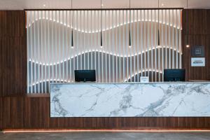 a lobby with a reception desk with a marble counter at AC Hotel by Marriott Georgetown Guyana in Georgetown
