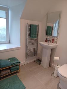 a white bathroom with a sink and a mirror at Hillview in Daliburgh +26 photos