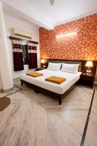 a bedroom with a large bed and a brick wall at New Mewar Darshan in Udaipur +5 photos