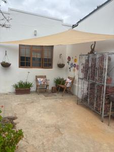 a patio with a canopy and chairs and a table at Parmant in Robertson