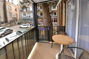 a balcony with a table and chairs and a tree at Cottage at Chavchavadze in Tbilisi City