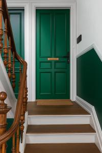 eine grüne Tür an einem Haus mit Treppe in der Unterkunft GreenBrook Homes in Aalborg