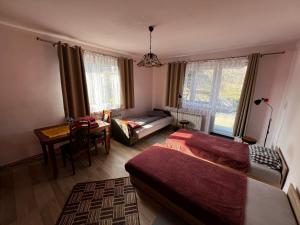a living room with two beds and a table at Pokoje Gościnne Pod Lasem" in Balice