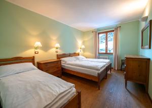 a bedroom with two beds and a window at Hotel Residence Valverde in Gressoney-la-Trinité