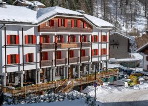 a large building with red windows in the snow at Hotel Residence Valverde in Gressoney-la-Trinité