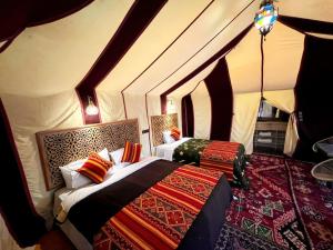 a bedroom with two beds in a tent at Stellar Luxury Camp in Merzouga