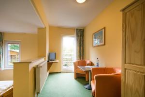 a hotel room with chairs and a table and a window at Pension Buchfink in Ueckeritz