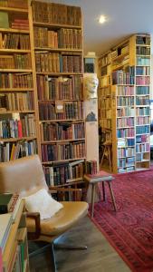 a library with a chair and a lot of books at Literaturhaus Schmökermühle in Andernach