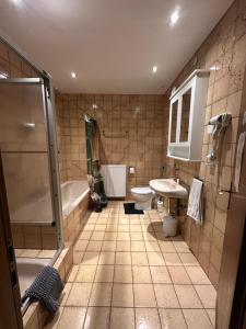 a bathroom with a tub and a toilet and a sink at Palminas Monteur FeWo EG in Merzig +3 photos