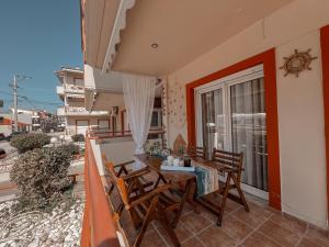 a balcony with a table and chairs and a window at Aurora Luxury Apartment in Keramoti