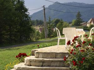 リュス・ラ・クロワ・オートにあるApartment with mountain viewsの白い椅子2脚(花の咲く石造りのパティオに座る)