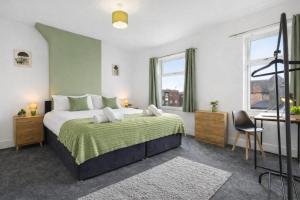a bedroom with a bed and a desk and windows at Comfortable 4 Bed Home - Free Parking & Brand New Bathroom in Denton +65 photos