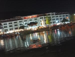a group of buildings at night next to a body of water at New shalimar dal view in Srinagar