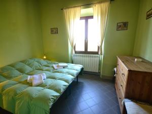 1 dormitorio con cama, ventana y vestidor en Scenic Apartment with Pool, en Poggio Alla Croce