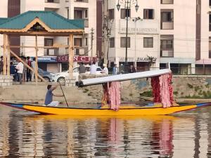 a man in a yellow boat on the water at New shalimar dal view in Srinagar