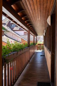 a wooden walkway with plants on the side of a building at The Originals Boutique, Hôtel La Ferme du Pape, Eguisheim in Eguisheim
