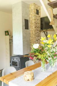a dining room table with a vase of flowers on it at Domek na Przylasku in Grywałd