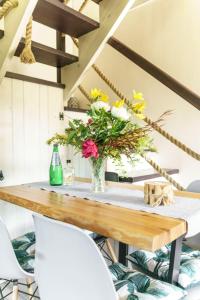 a dining room table with a vase of flowers on it at Domek na Przylasku in Grywałd