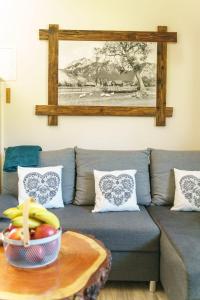 a living room with a couch with a bowl of fruit on a table at Domek na Przylasku in Grywałd +25 photos