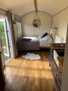 a bedroom with a bed in a tiny house at Trouble House in Tetbury