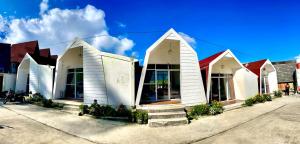 a row of white buildings with stairs in front at Glamping Calla in Banjarnegara