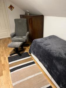 a bedroom with a bed and a chair next to a bed at Sahlin - Kattarp in Kattarp +28 photos