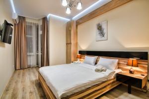 um quarto com uma cama grande e uma mesa com candeeiros em Apartments Alfa Tsekhova 1 em Lviv